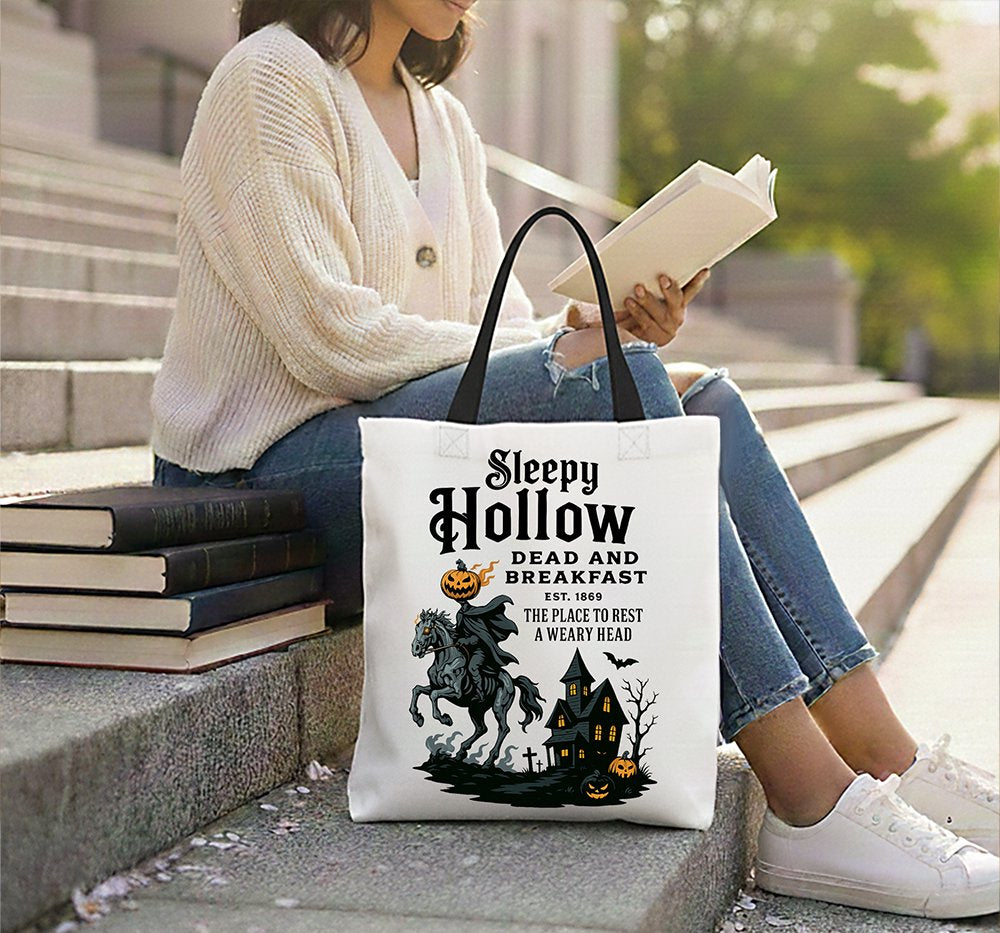 Person sitting on steps with a tote bag featuring 'Sleepy Hollow' design