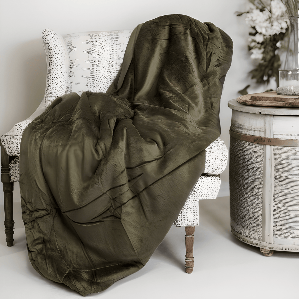 Green blanket draped over a chair in a room with a decorative side table.