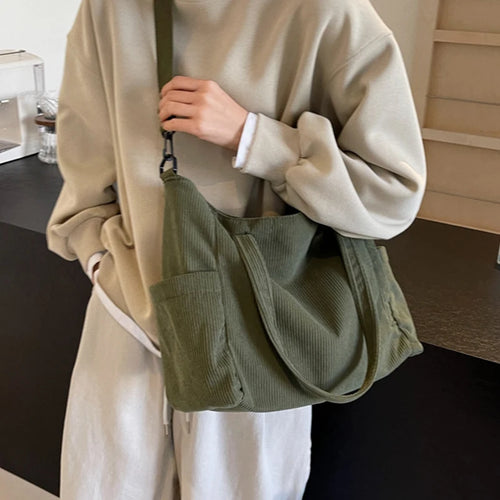 Person holding a green bag indoors