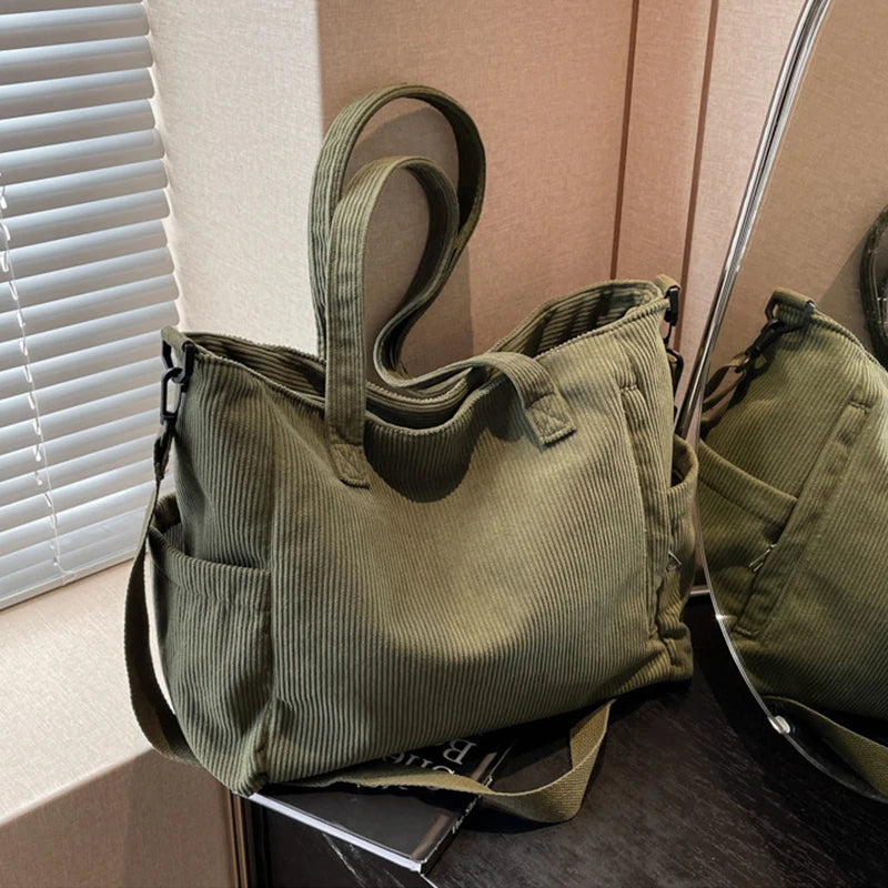 Green corduroy bag on a surface with a neutral background