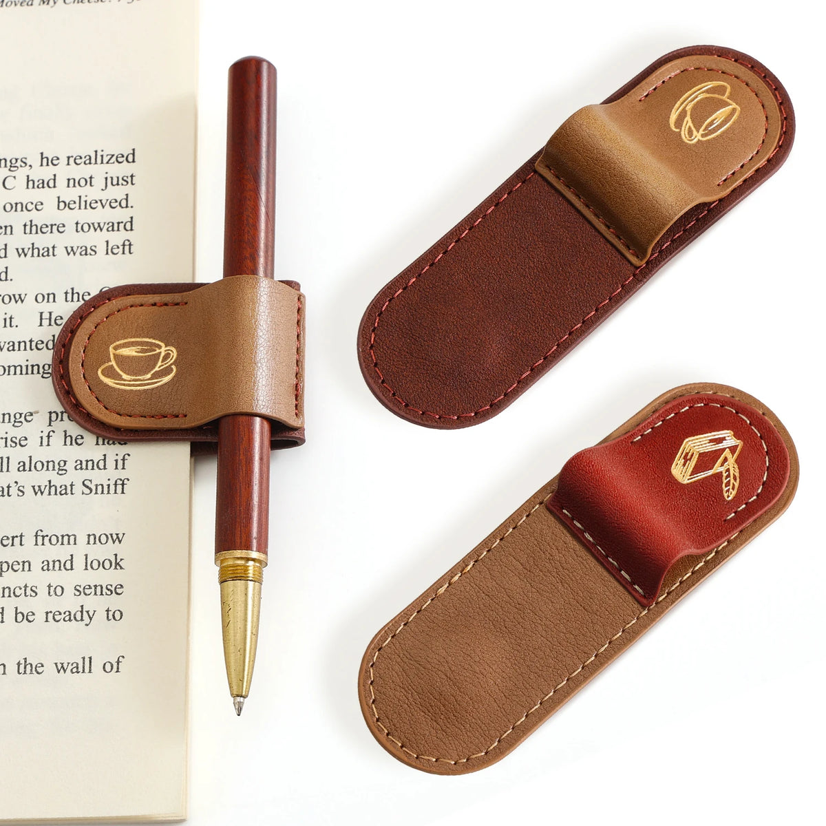 Two brown leather pen and pen holder sets displayed on a white background, one set holding a wooden pen with a gold tip, next to a book page.