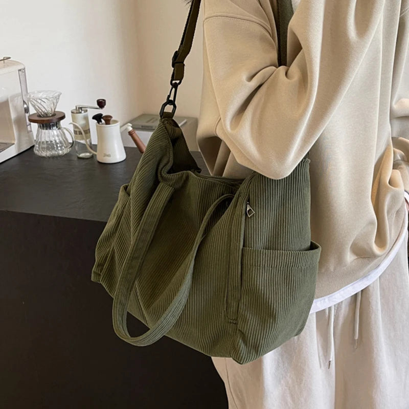 Person holding a green corduroy bag in a kitchen setting