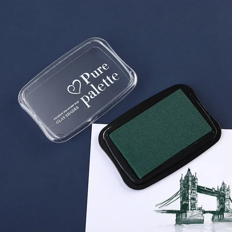 Green paint pad with 'Pure Palette' lid on a dark blue background
