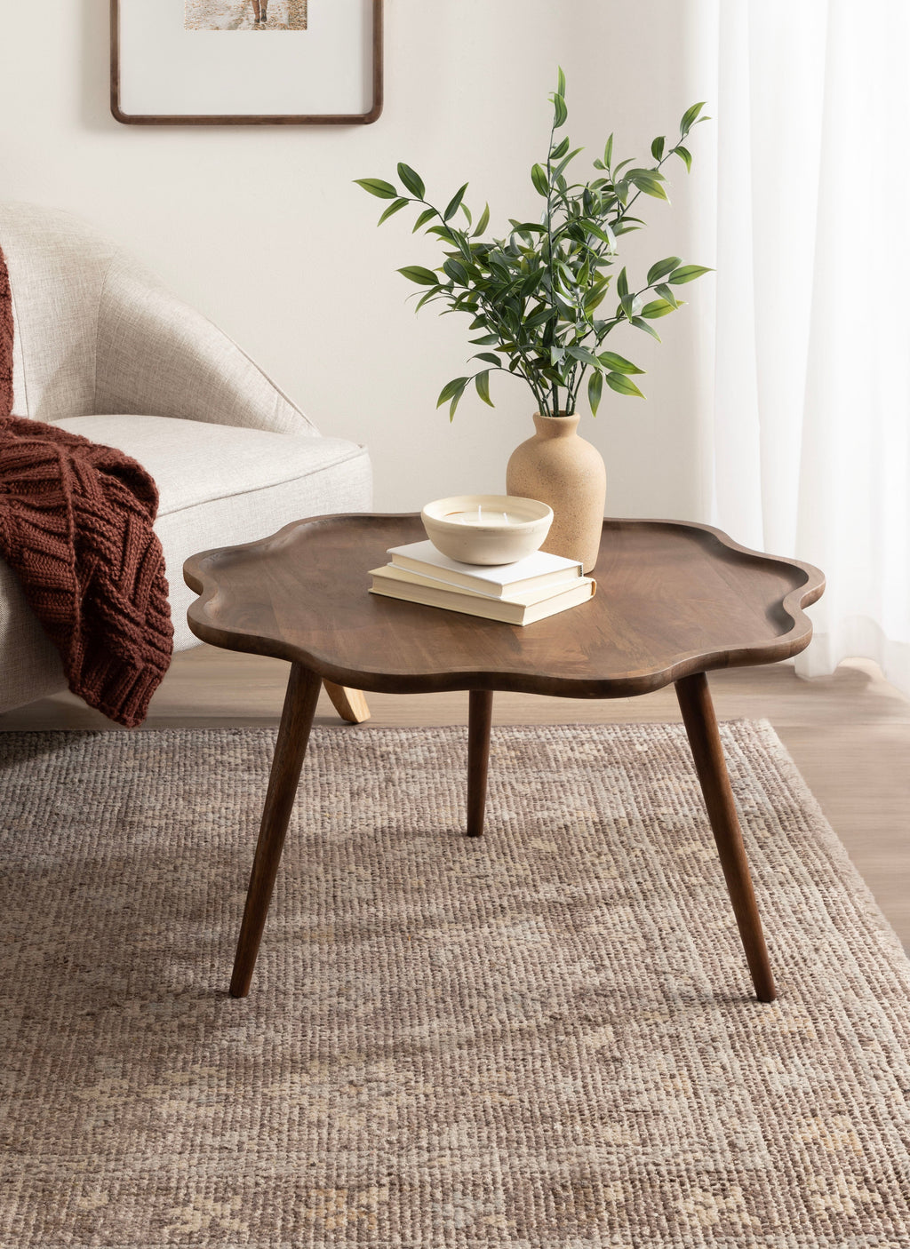 Wooden side table with a vase and books in a living room setting